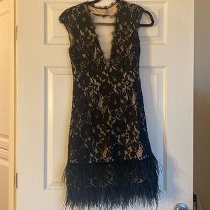 CAP SLEEVE LACE COCKTAIL DRESS WITH FEATHER TRIM IN BLACK NUDE